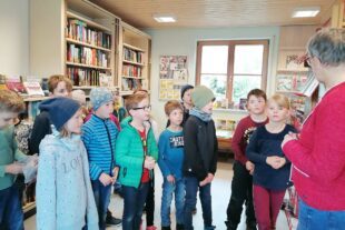 2023-5-2-BI-Wiebke Fix-Erstklässer zu Besuch bei Bücherei-Andrea Mäntele erklärt die Bücherei