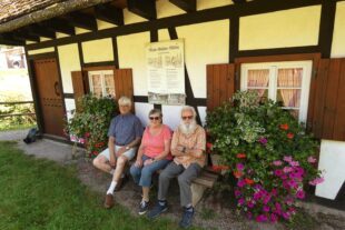 2024-8-28-NO-bia-Mühlenmeister-und-Trio auf Bank vor Mühle