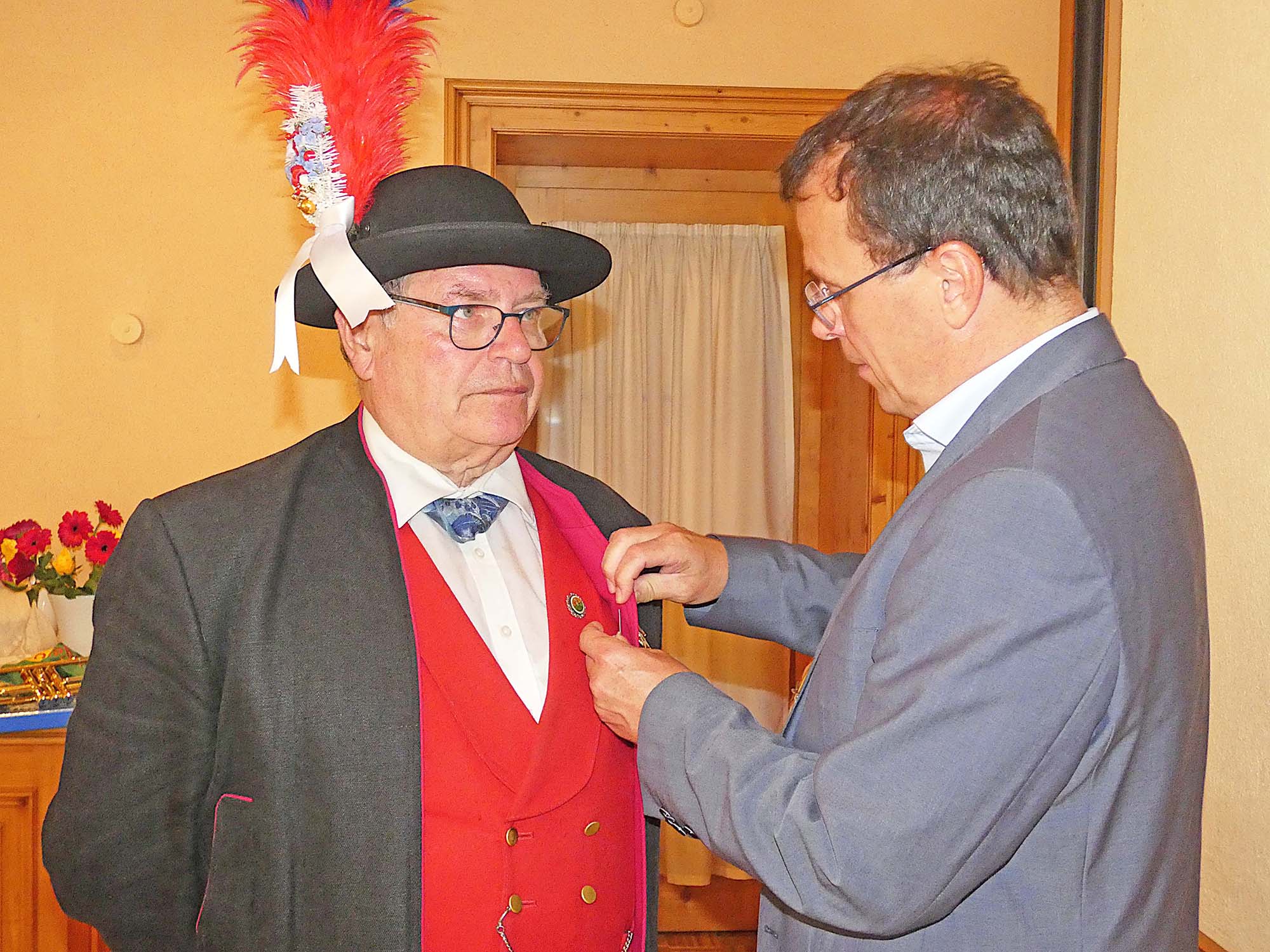 2025-6-20-OH-bia-Historische Bürgerwehr Oberharmersbach-Ehrungen 2025+ SP Schebesta steckt Nitsche Ehrennadel an