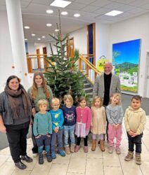 Kindergartenkinder schmücken den Weihnachtsbaum bei der Volksbank