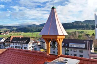 Das neue Glockentürmchen schwebt auf das sanierte Rathausdach default