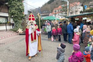 2025-12-5-NO- von 2024-12-6-NO-Touristen-Info-Weihnachtsmarkt-Der Nikolaus beschenkt die Kinder und freut sich über ein Gedicht oder ein kleines Lied